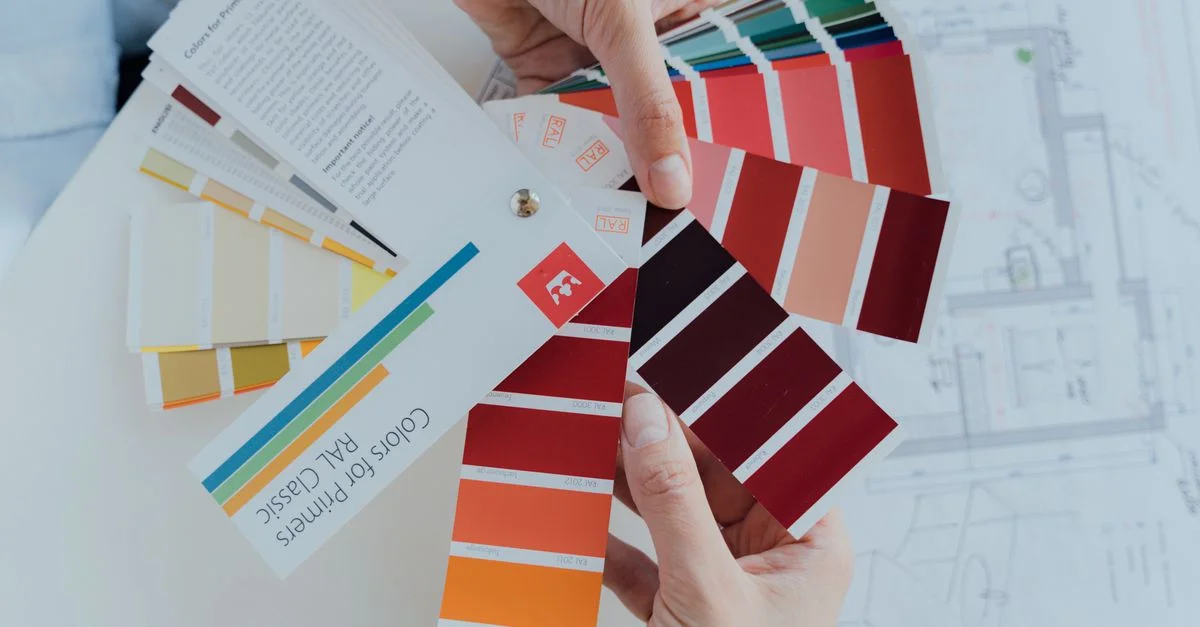 Personne choisissant des palettes de couleurs pour des projets de design d'intérieur, mettant en avant des choix créatifs.