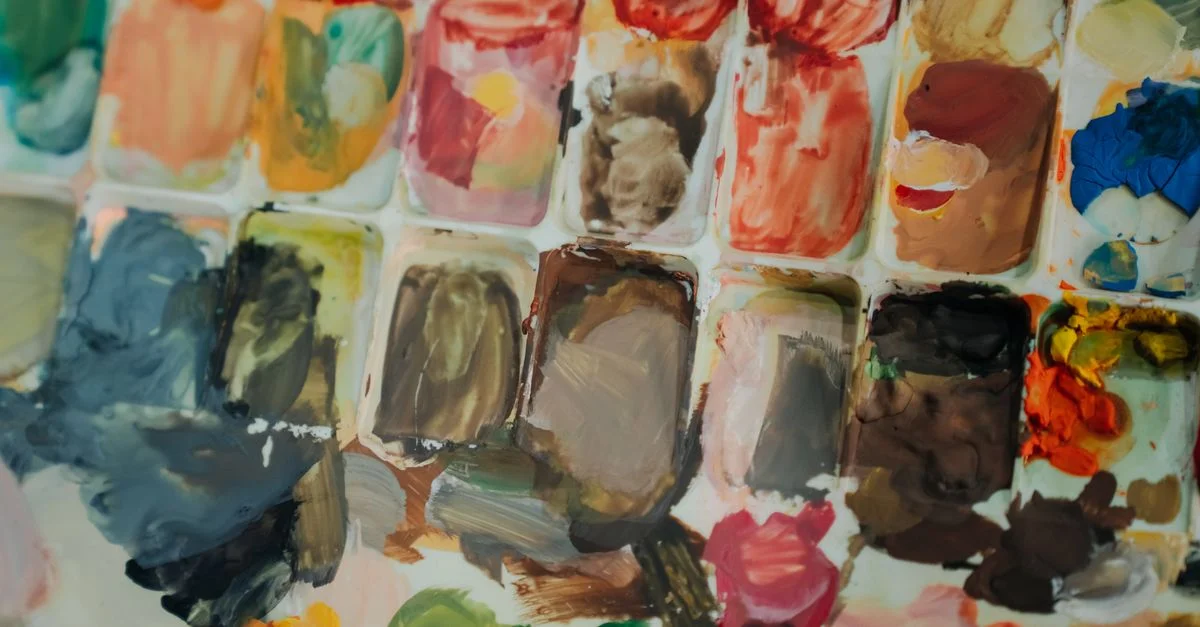 Gros plan d'une palette d'artiste aux couleurs vives avec un mélange de diverses peintures à l'huile prêtes à être utilisées de manière créative.