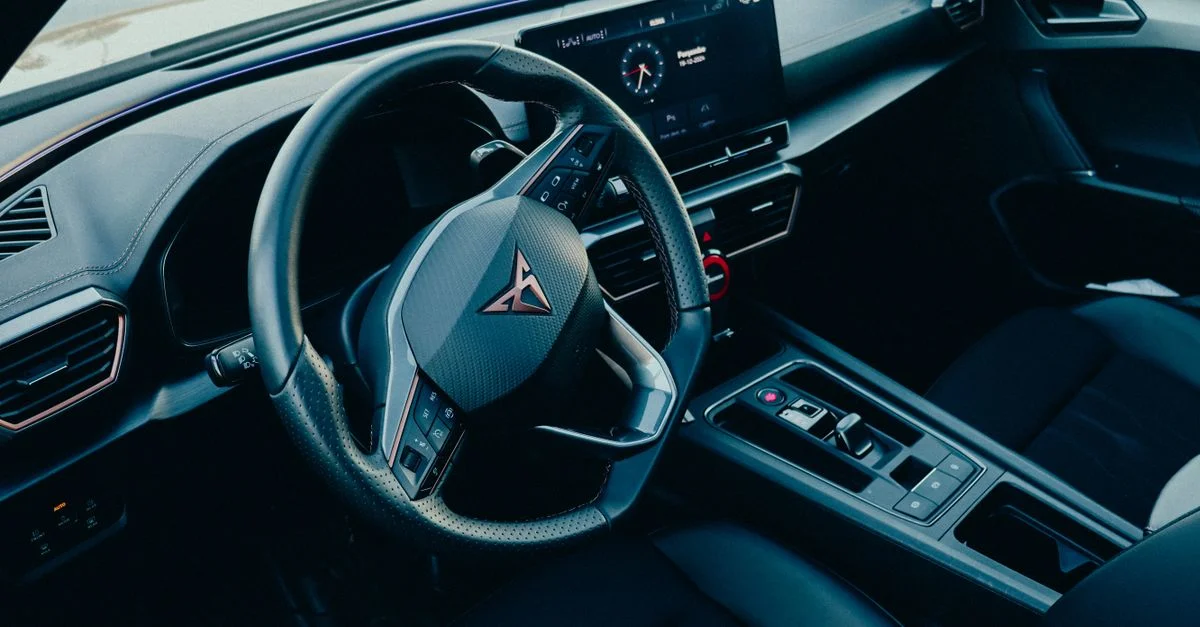 Vue en plongée d'un intérieur de voiture moderne avec un tableau de bord élégant et un volant.