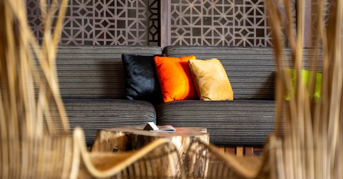 Salon contemporain avec des coussins vifs sur un canapé rayé, décoré avec du bois élégant.
