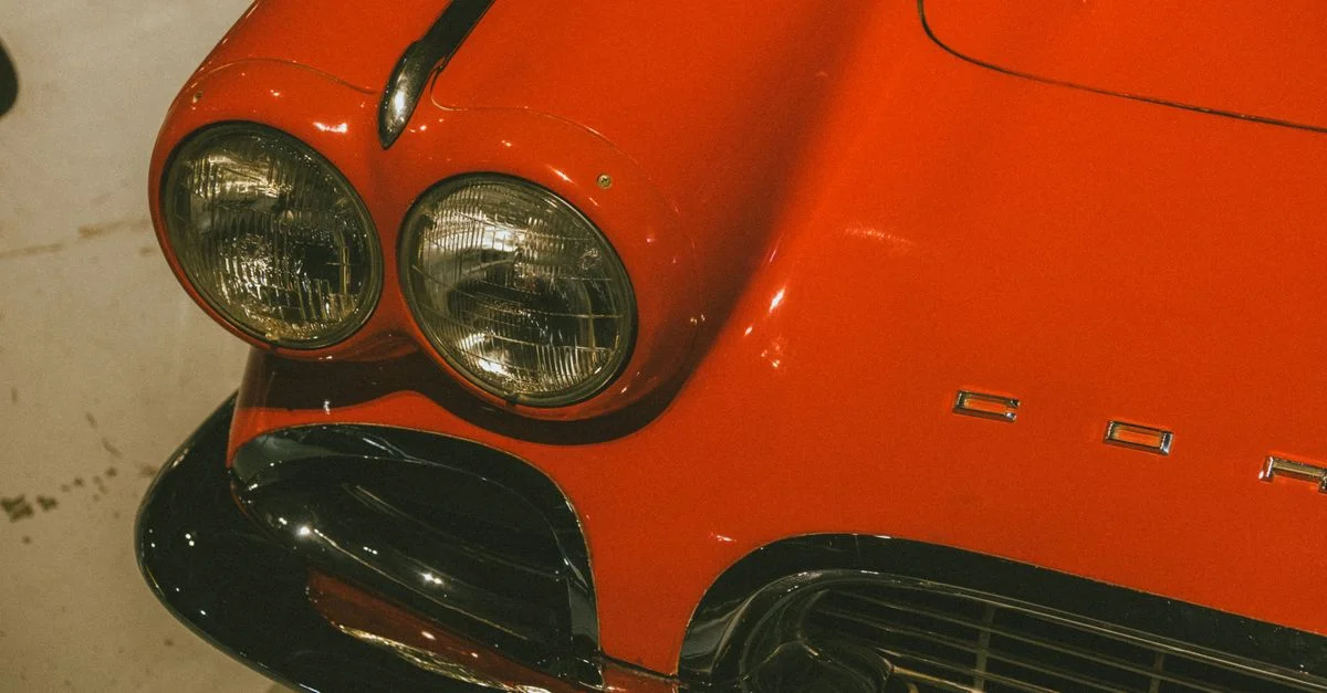 Gros plan sur une voiture de sport rouge vintage à double phare, mettant en valeur des éléments de design classiques.
